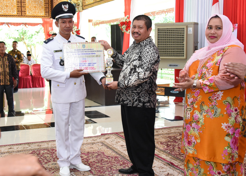 Teks foto: Bupati Bengkalis, Amril Mukminin menyerahkan penghargaan kepada Kepala Desa Teluk Lecah, Azmi sebagai desa terbaik tahun 2018.