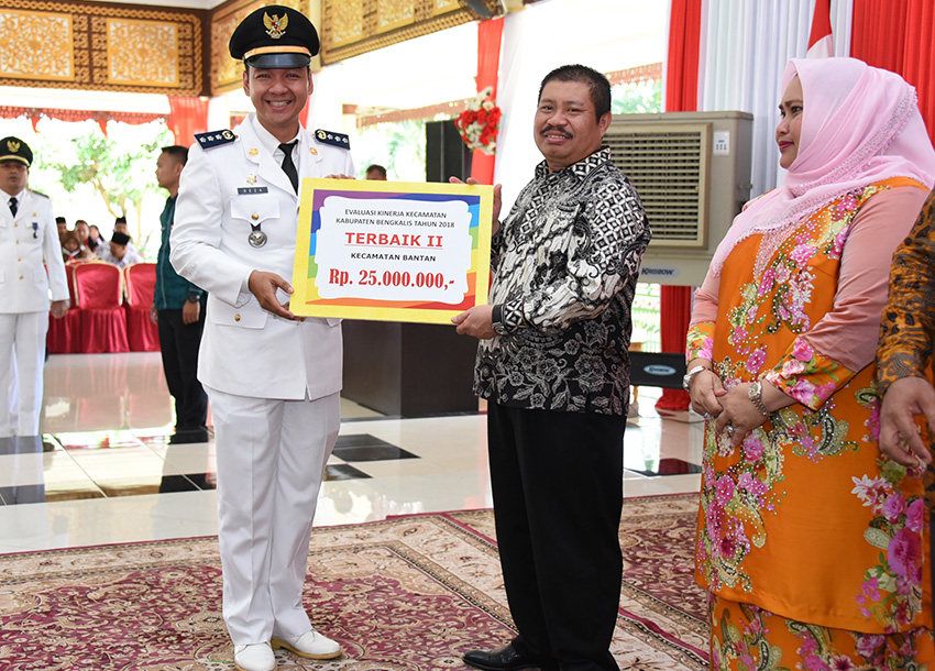 Teks foto: Bupati Bengkalis, Amril Mukminin menyerahkan penghargaan kepada Camat Bantan, Reza Noverindra.