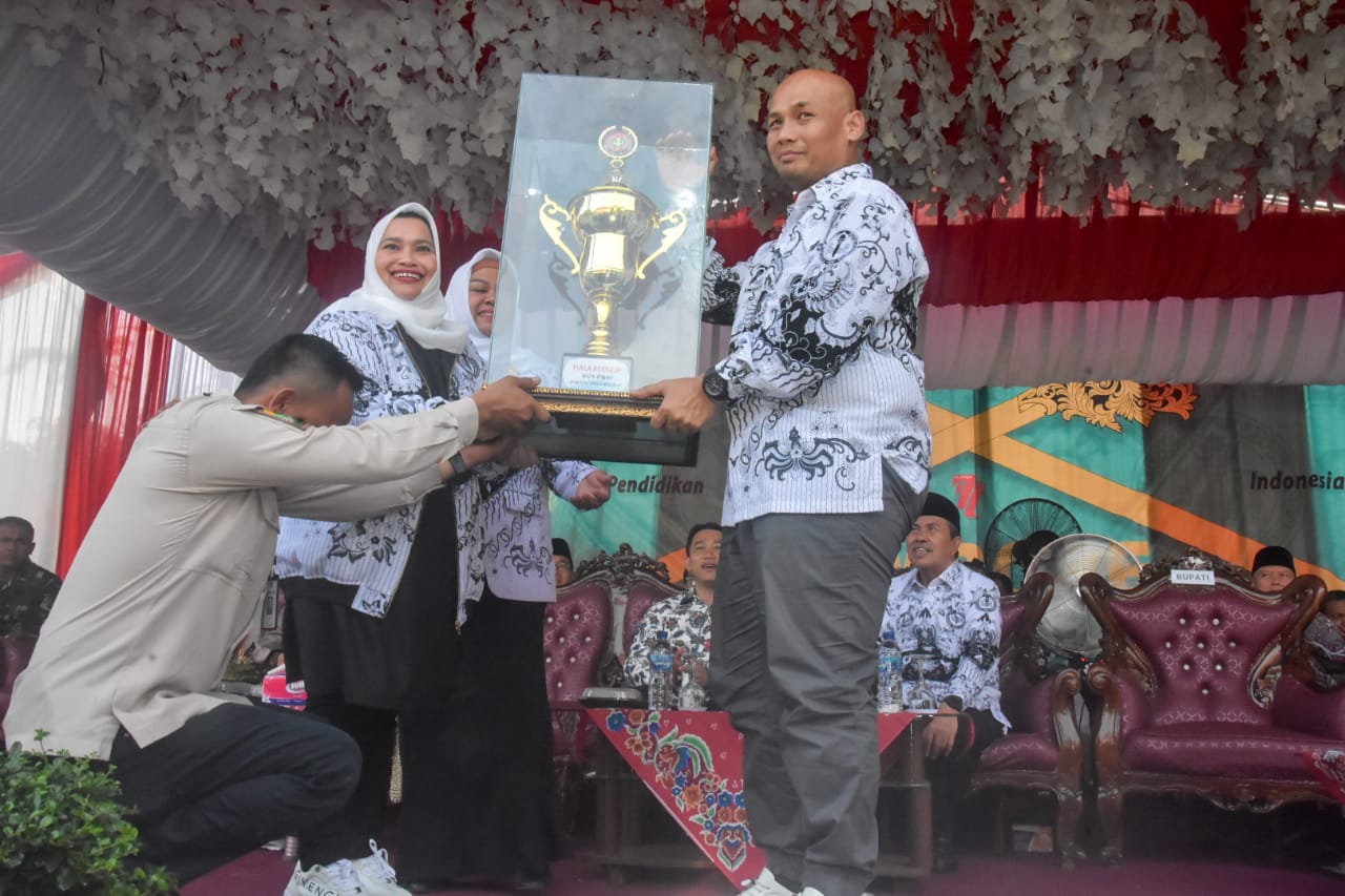 Bupati Kasmarni menyerahkan piala bergilir kepada Ketua PGRI Provinsi Riau 
